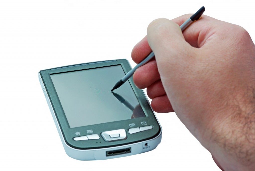PDA phone with touch screen and stylus in hand.