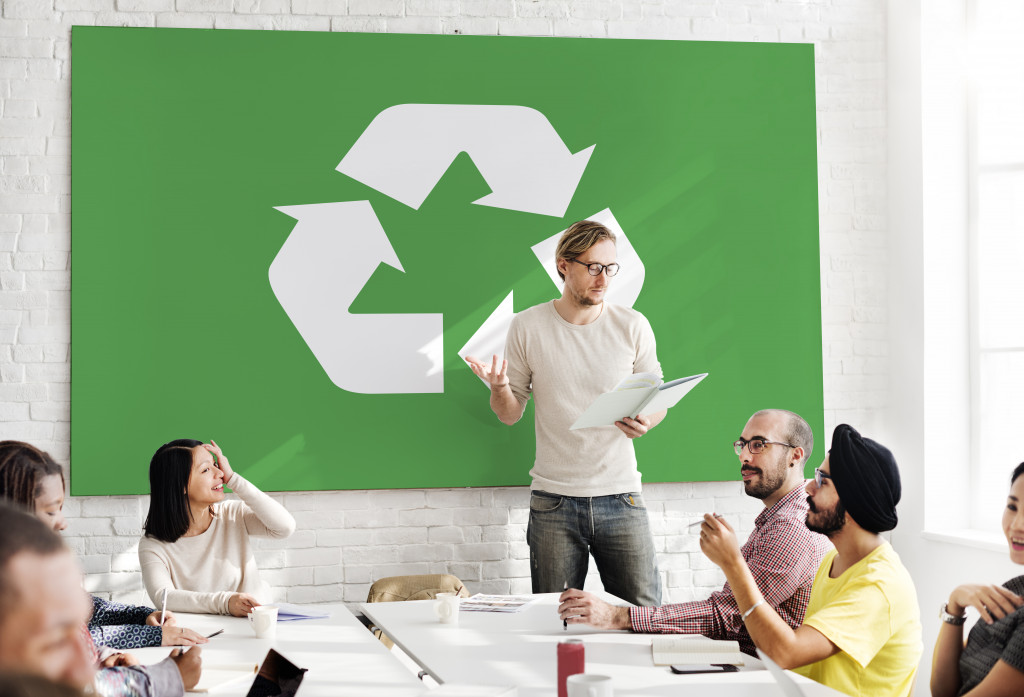 a startup having a meeting with a banner with recycling banner on the wall