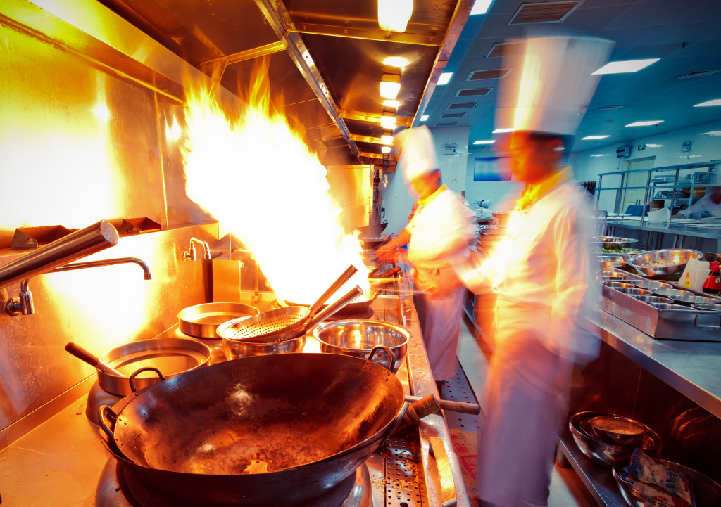 chefs with a flaming wok