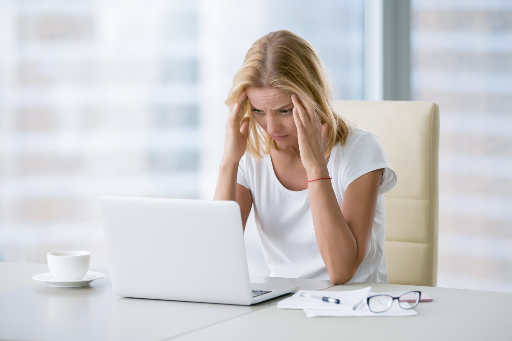 female business owner in her desk with headache