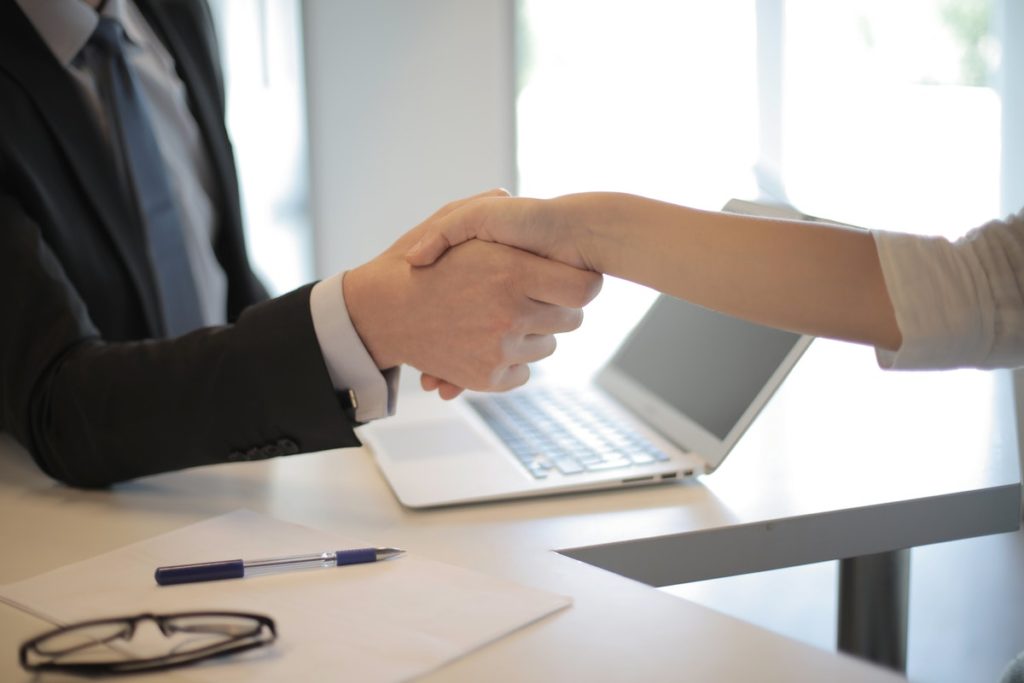 hiring manager shakes hands with newly hired employee