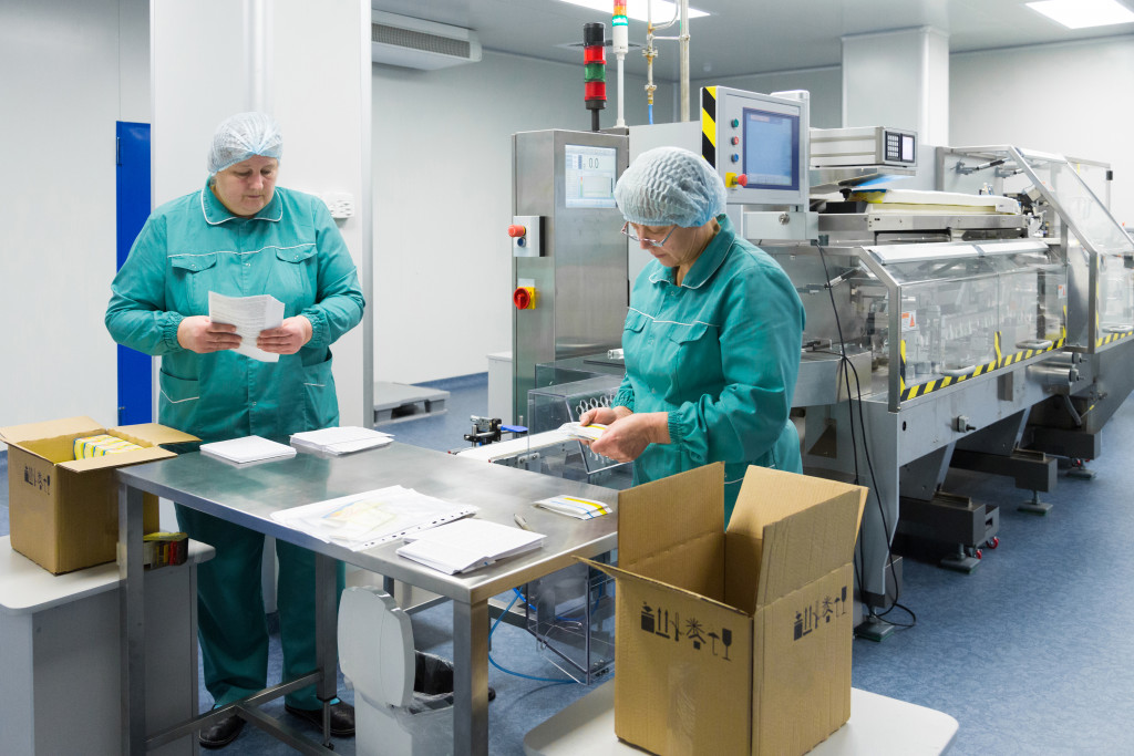 Two pharmaceutical company workers inside a sterilized factory