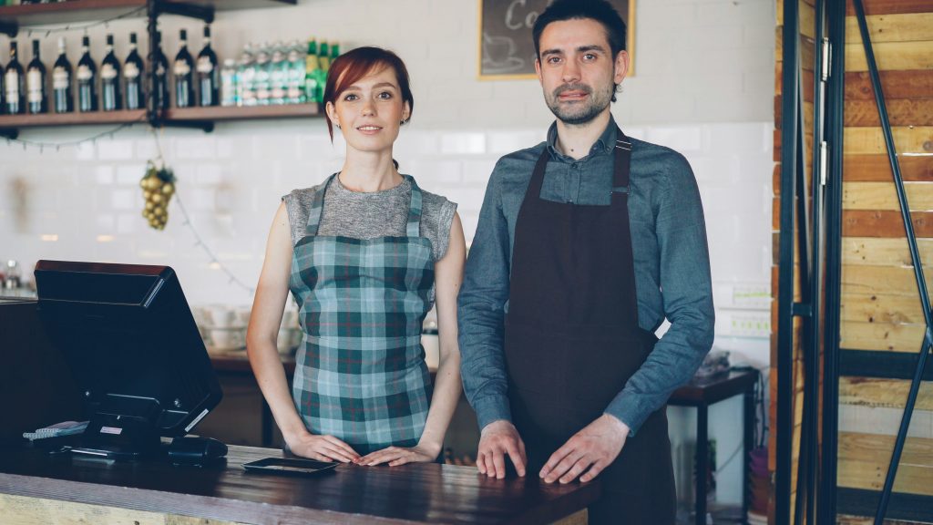 two restaurant owners standing behind the counter
