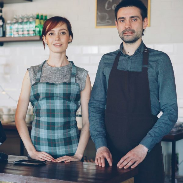 two restaurant owners standing behind the counter