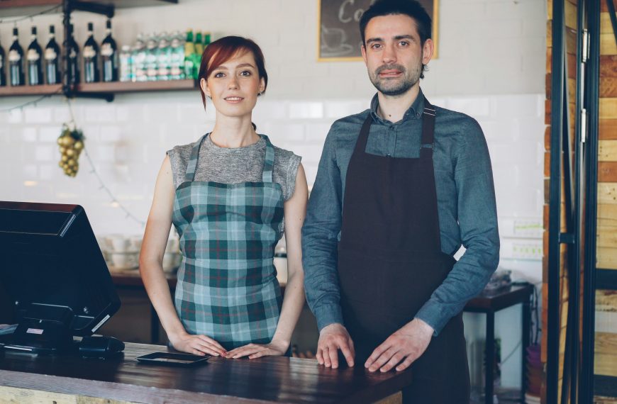 two restaurant owners standing behind the counter